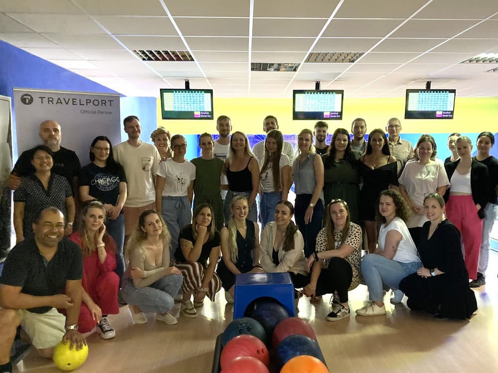 Účastníci bowlingového stretnutia vo Zvolene 2024 v herni s bannerom Travelport