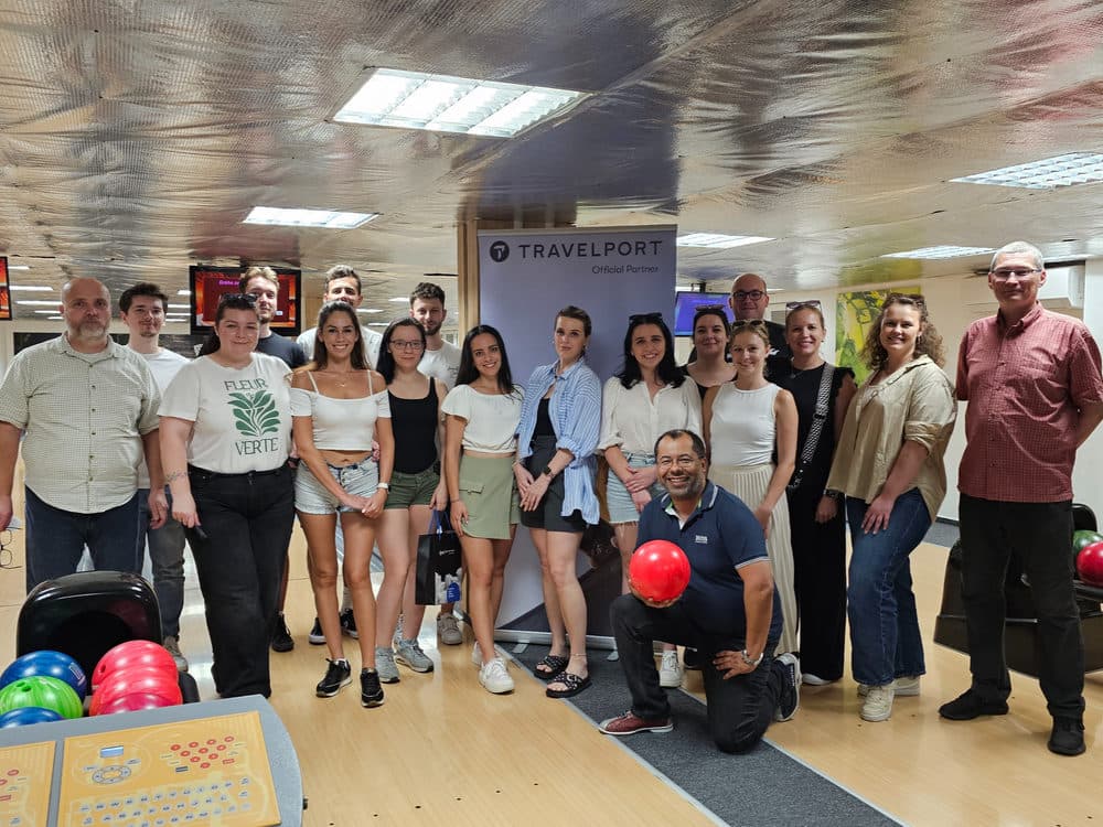 Účastníci bowlingového stretnutia vo Zvolene s bannerom Travelport
