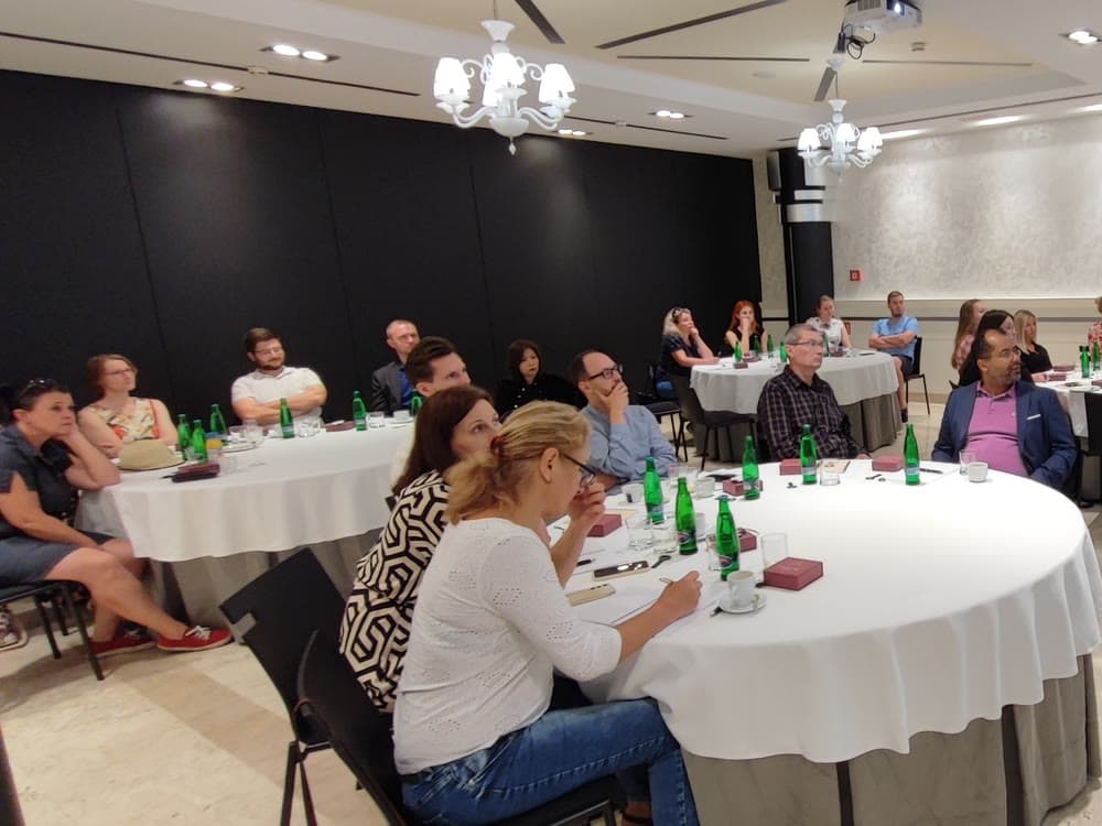 Hostia NDC bruncha pri okrúhlych stoloch v sále brnianskeho hotela Grand Palace